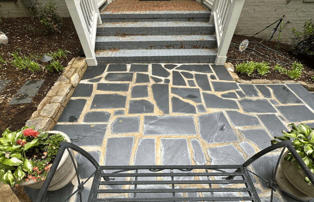 Flagstone patio with brick steps leading to a residential entryway